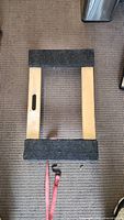 Top view of the dolly showing wooden frame with padding and handle cut-outs.