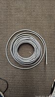 Coil of BX electrical wire with metallic flexible armored conduit on beige carpet