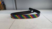 Photo of the 40-inch rainbow studded belt laid flat, showing the multicolored square studs in a rainbow pattern.