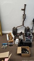 Full lot view showing exhaust system components, intake and manifold parts, suspension struts, boxes of small parts and wiring