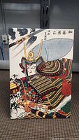 Front view of a colorful samurai picture artwork showing the armored warrior with detailed helmet and background calligraphy.