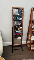 Full view of the standing mirror showing its wooden frame and metal legs.