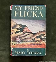 Front cover of 'My Friend Flicka' with dust jacket showing wear and illustration of children and horse in western landscape.