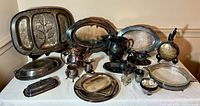 Wide view of all plated silver servingware and Pyrex casserole displayed on table