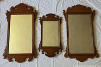 Three vintage Chippendale-style maple-framed mirrors laid side-by-side on white cloth background, showing overall condition and detailing for scale.