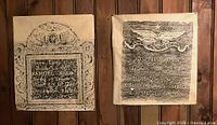 Two gravestone rubbings on tissue paper hung side by side on wood paneling wall