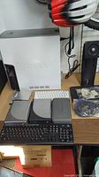 Overview of Dell desktop tower with keyboards and optical drives on table.