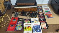 Sears Tele-Games console with controllers and multiple game instruction manuals and catalogs laid out on table.