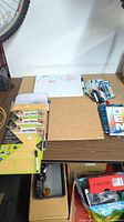 Lot with dry erase board, corkboard, several Re:Writes erasable pads, assorted pens, markers, and sticky notes on a small table.