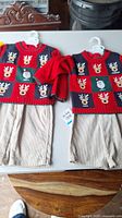 Photo of two matching new boys' outfits 18M and 24M on hangers showing sweaters and pants distinctly