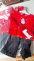 Set of two holiday outfits for toddler girls, size 18-24 months, displayed with tops, pants and matching red shoes.
