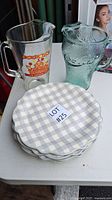 Pitcher, glass and covered plates shown together on table