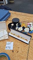 Overview of jewelry lot showing charm bracelet in box, wristwatch in round case, pearl necklace box and floral headbands