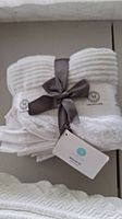 Set of white Martha Stewart hand towels tied with dark ribbon showing brand tag