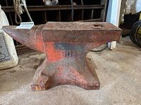 Side view of full anvil showing horn, face, and base with paint residue.