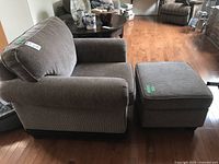 View of armchair and ottoman set from the side showing fabric and wooden base details