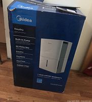 Photo of original blue box showing front and brand Midea with product image and features list.