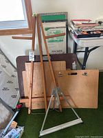 Wooden tripod easel in front of boards and paper pad
