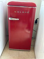 Front view of red Galanz refrigerator with chrome handle and retro styling.