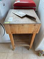 Front and top view of the wood butcher block cart with the Henry Boker cleaver resting on top, showing the thickness and joinery of the block.