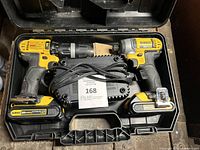 Two DeWALT 20V Max cordless tools, two batteries and charger arranged inside plastic carrying case