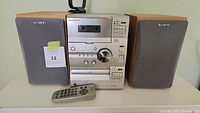 Complete Sony micro hi-fi system with cassette, CD player, radio and two speakers. Also includes remote control in front.