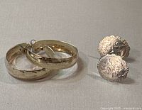 Two pairs of sterling silver earrings, one pair of hoops and one pair of studs with engraved designs