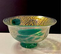 Angle view showing the gold speckled texture with green swirls inside.