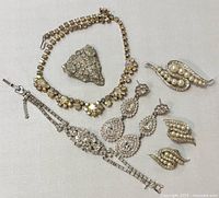 All items laid out on flat surface showing full lot with necklace, brooch, bracelet, earrings pairs.