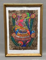 Framed Mexican folk art painting with bright colors on bark paper depicting a bird and flowers.