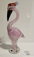 Photo of modern art glass flamingo figurine showing side profile with curved neck and pink body