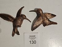 Front view of two copper hummingbird wall decorations featuring detailed wings and body patterns.