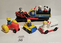 Photo of the full lot showing a red tractor, yellow-blue vehicle, white ambulance, and black snowmobile vehicle with figures