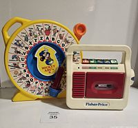 Photo of Fisher Price Mickey ABC Wheel of Sounds and tape recorder toys side by side showing front view