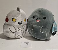 Front view of Mecha Godzilla and Godzilla Squishmallows showing faces and front body details