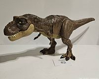 Front-right angled side view of large brown Jurassic World T-Rex dinosaur toy showing detailed body and head with open mouth and yellow eyes on neutral background with lot number.
