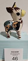 Side angle showing the hand-painted floral patterns and glaze finish on the ceramic donkey figurine.