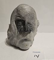 Front view of the soapstone face carving showing detailed facial features and shading.