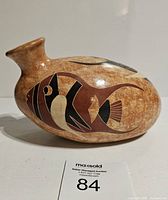 Side view of vintage pottery water jug showing detailed fish motif and spout.