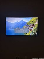 Photo of 43-inch LG TV mounted on wall showing no signal message with scenic background image.