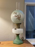 Full view of the Victorian Gone With The Wind hand-painted parlor oil lamp showing the glass globe, ornate brass burner, white reservoir, and rare green ribbed glass base.