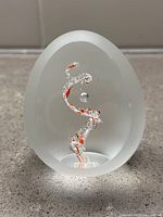 Front view of the frosted egg-shaped paperweight showing the red and clear DNA helix inside.