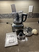 Overview of Cuisinart food processor with accessories and manual on countertop