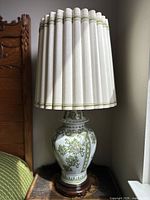Full view of the lamp showing hand painted floral porcelain base and the full wooden slat shade on top