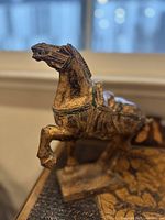 Front angle of the carved vintage wooden horse statue showing detailed head and raised front leg.