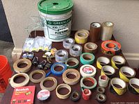 Wide view of all tape rolls, bucket, and hardware items for clear overview.