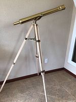 Full side view of extended telescope on wooden tripod