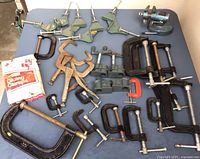 Full view of all clamps and vice on table showing variety and sizes