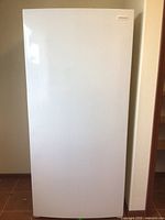 Front view of closed white upright freezer