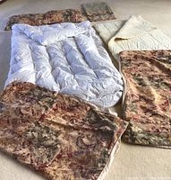 Full display of set including white goose down comforter spread, multiple patterned duvet covers and pillow shams